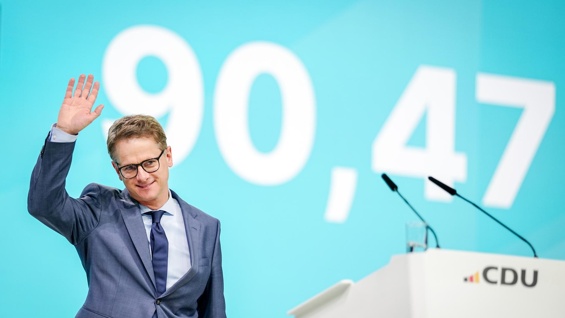 Carsten Linnemann, CDU-Generalsekretär, beim Bundesparteitag in Stuttgart. Er steht auf einer Bühne und winkt. Carsten Linnemann, CDU-Generalsekretär, beim Bundesparteitag in Stuttgart. Er steht auf einer Bühne und winkt.