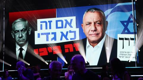 Netanjahu und Eisenkot sind auf einem großen Plakat abgebildet, Netanjahu mit rotem, Eisenkot mit blauem Hintergrund.