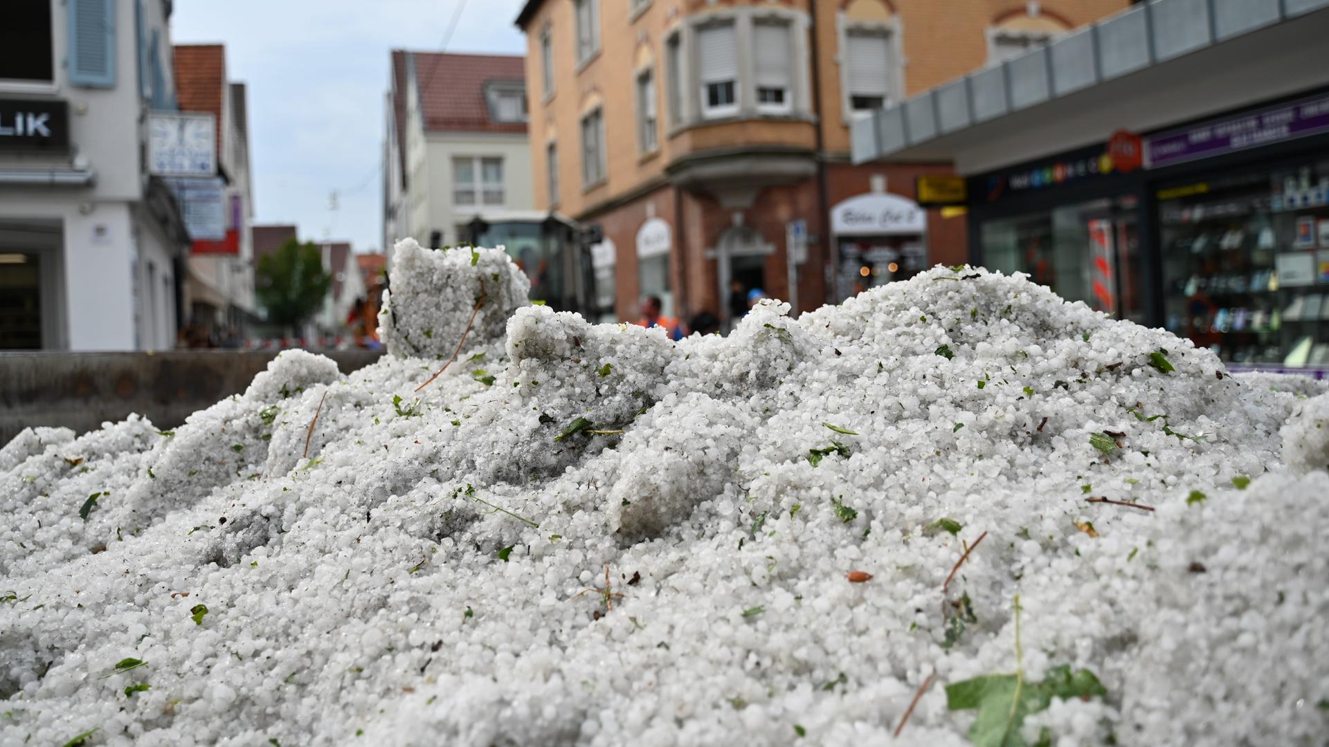 Baden-Württemberg, Reutlingen: Hagelkörner liegen nach einem Unwetter in einem Container in der Innenstadt. 