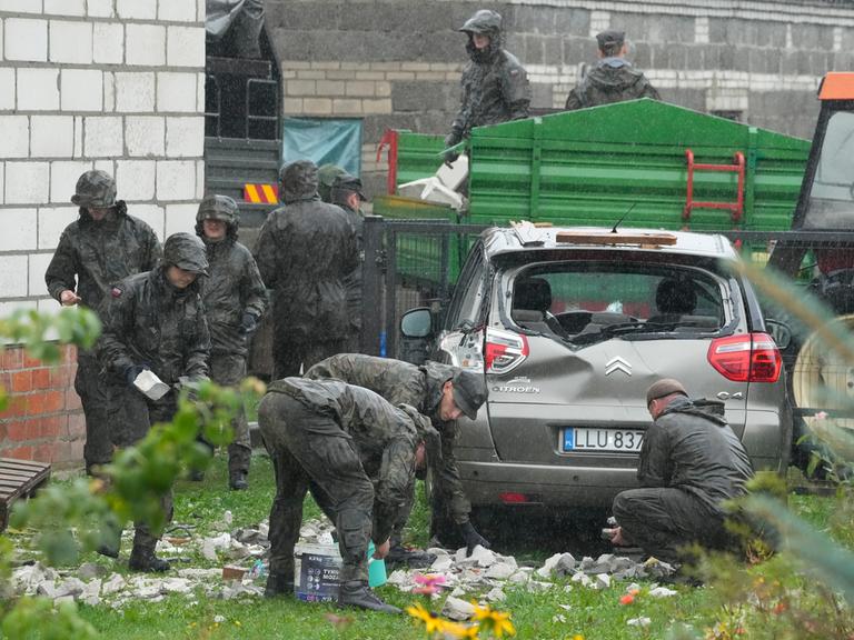 Aufräumarbeiten rund um ein zerstörtes Dach und ein Auto, nachdem russische Drohnen den polnischen Luftraum verletzt haben