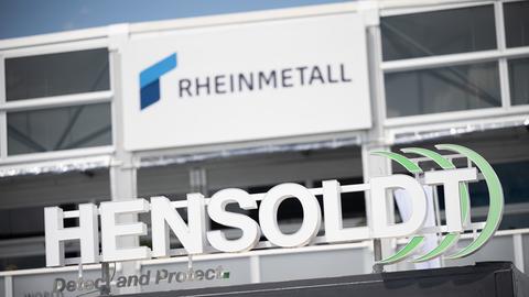 Das Logo des Luft- und Raumfahrtunternehmens Hensoldt vor dem Logo des Rüstungsunternehmens Rheinmetall