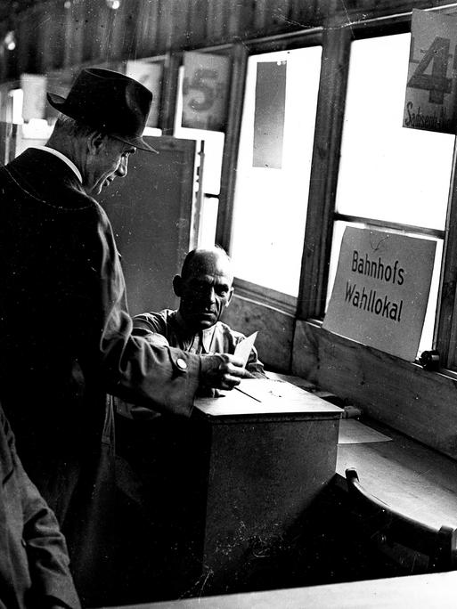 Wahlen zum 1. Deutschen Bundestag: Ein Reisender gibt im Wahllokal auf dem Hauptbahnhof Frankfurt am Main seine Stimme ab.