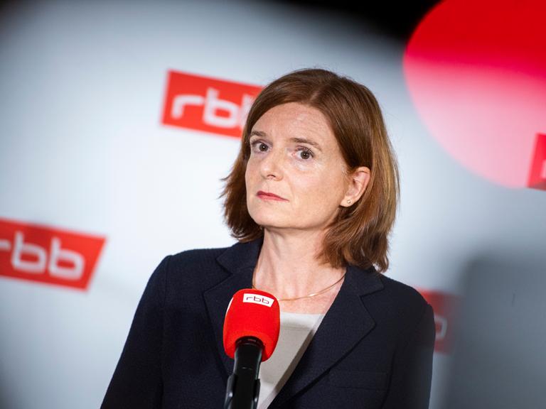 Katrin Vernau, die neue Interimsintendantin beim RBB, steht bei einer Pressekonferenz nach der RBB-Rundfunkratssitzung vor einem Mikrofonen mit rbb-Symbol.