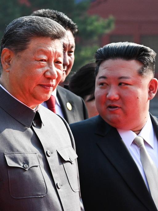 Xi Jinping (m) tritt mit Putin (l) und Kim Jong Un (r) an seiner Seite vor die Kameras.
