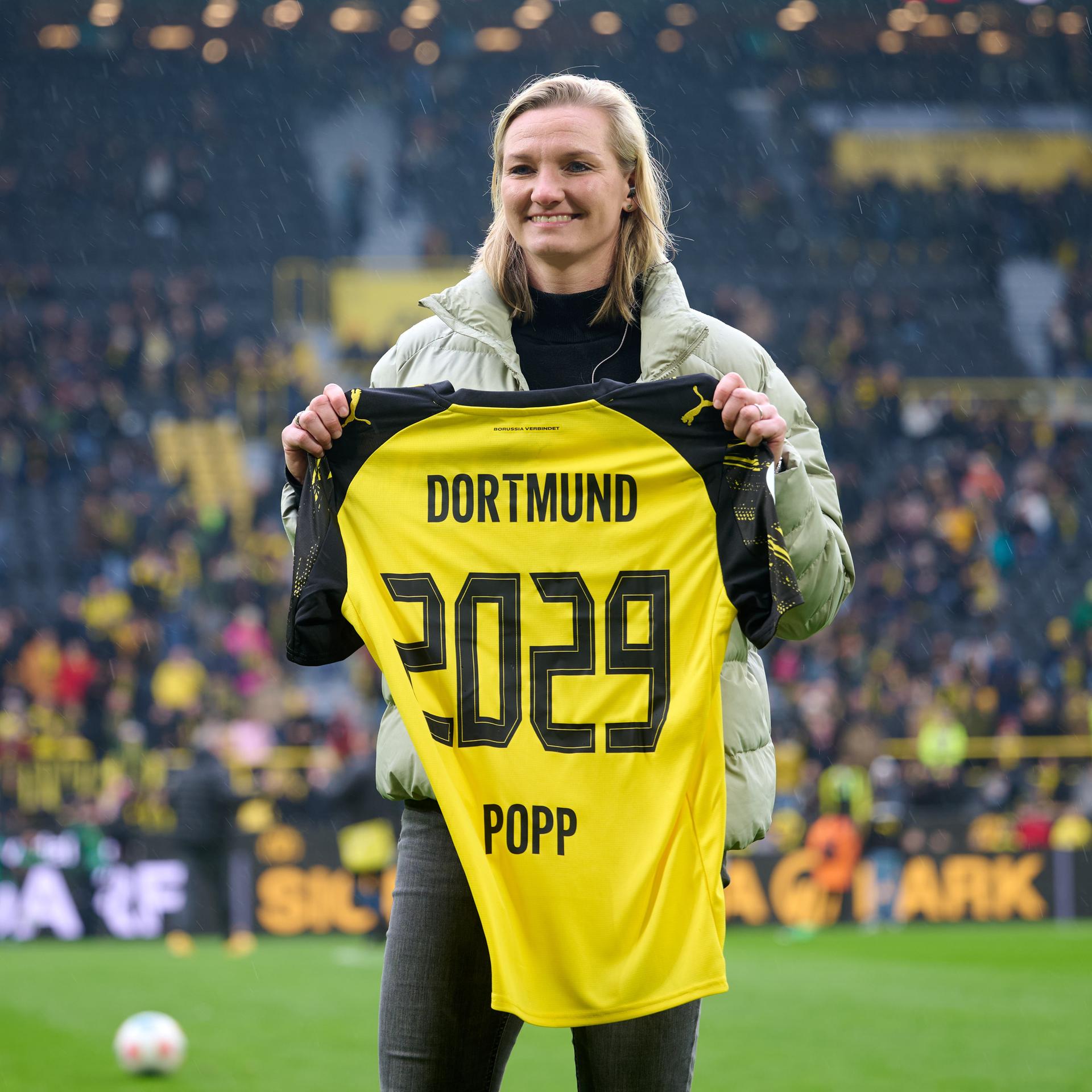 Alexandra Popp steht mit einem Trikot ihres neuen Vereins Borussia Dortmund mit der Nummer 2029 auf dem Rasen des Signal-Iduna-Parks.
