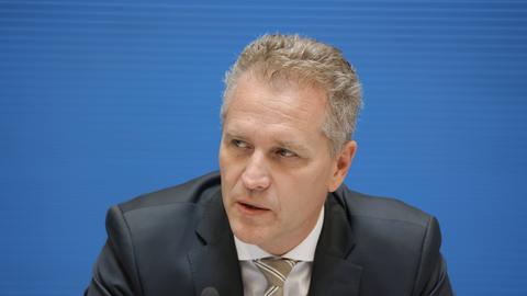 Der AfD-Abgeordnete Petr Bystron vor einem blauen Hintergrund. Er schaut ein bisschen zur Seite. Sein Mund ist etwas geöffnet.