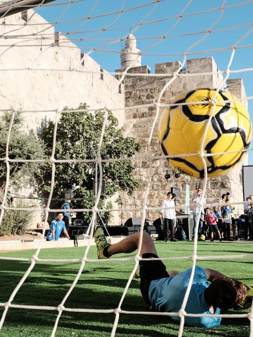 Jugendliche spielen in der Nähe des Jaffatores in Jerusalem Fußball.
