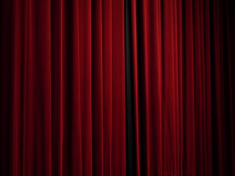 Ein geschlossener roter Vorhang im Theater 