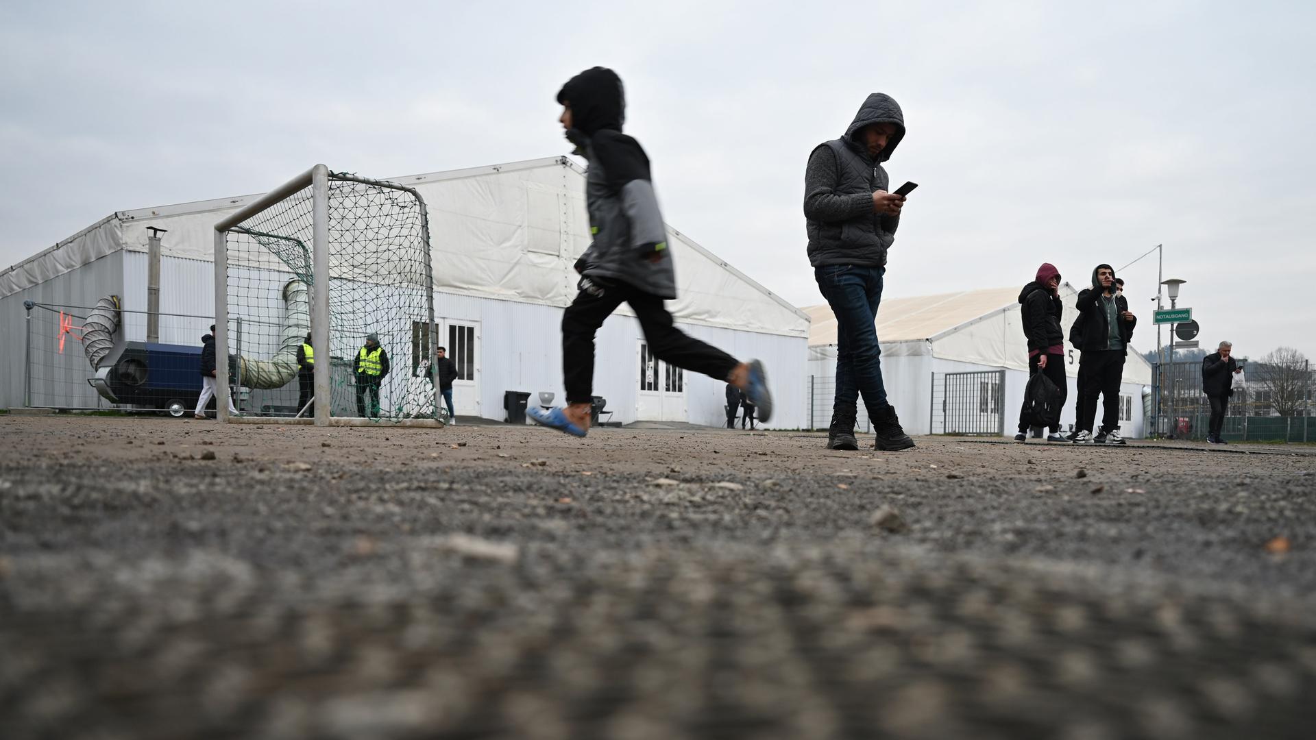 Flüchtlinge halten sich auf dem Gelände der Flüchtlingsunterkunft vor den Zelten auf. Städte und Gemeinden können die Zahl der Geflüchteten kaum noch unterbringen. Nicht nur der Kreis Bergstraße fordert daher mehr Unterstützung von Bund und Land.