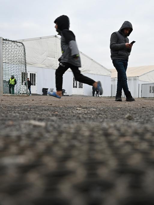 Flüchtlinge halten sich auf dem Gelände der Flüchtlingsunterkunft vor den Zelten auf. Städte und Gemeinden können die Zahl der Geflüchteten kaum noch unterbringen. Nicht nur der Kreis Bergstraße fordert daher mehr Unterstützung von Bund und Land.
