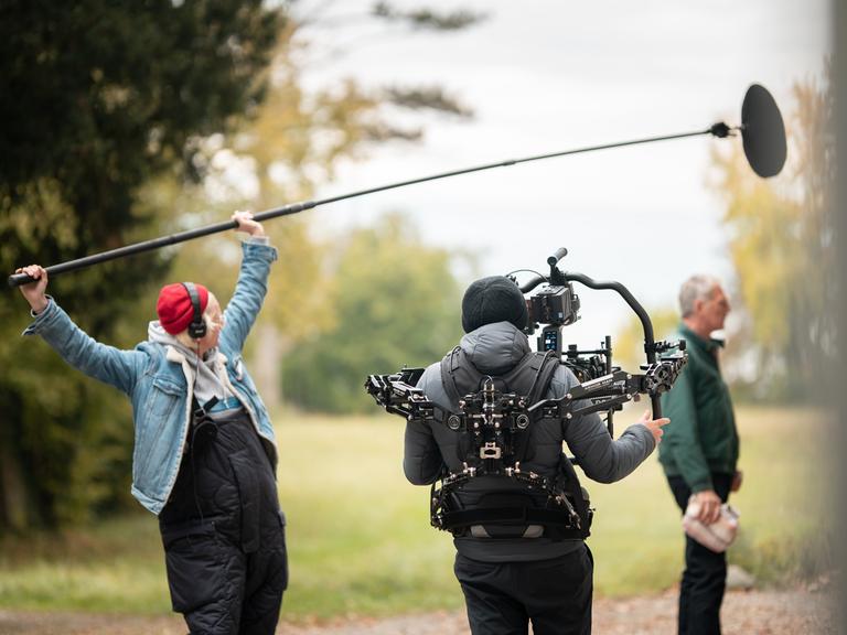 Kameramann filmt den Schauspieler Walter Sittler während Dreharbeiten zu dem Krimi "Der Kommissar und der See".