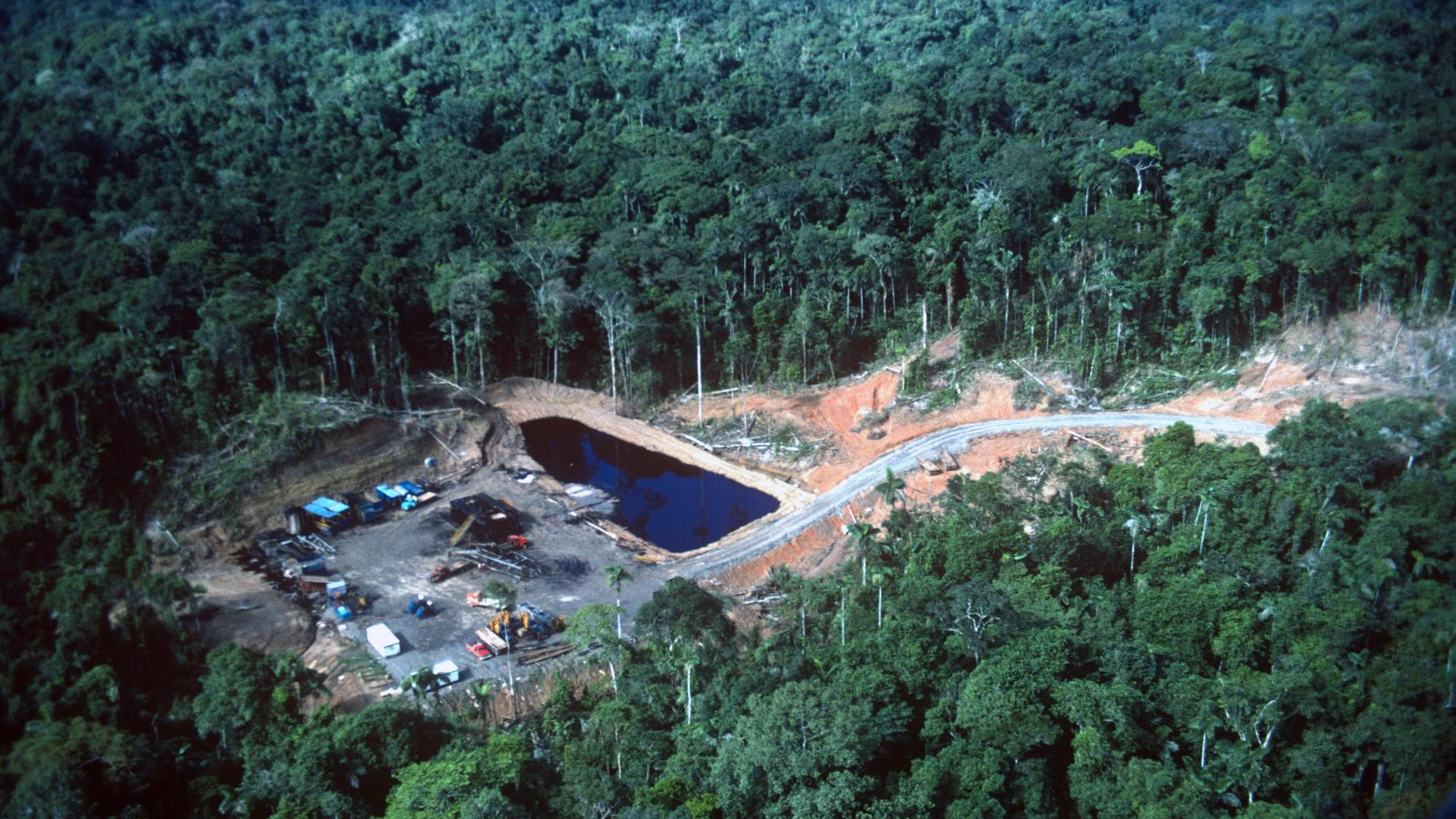 Aus der Vogelperspektive ist eine Ölförderanlage mitten im Regenwald zu sehen.
