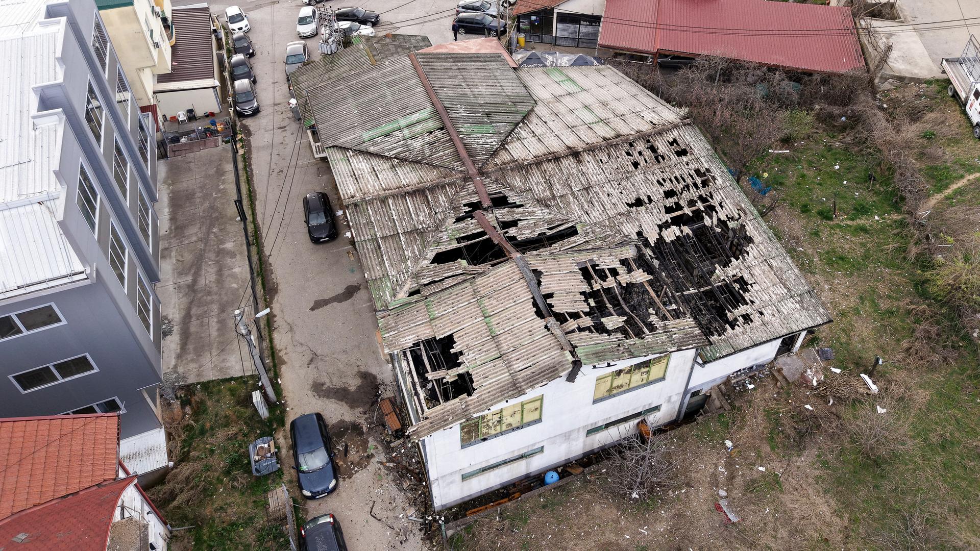 Der Blick von oben auf den ausgebrannten Nachtclub in Kocani in Nordmazedonien zeigt große Löcher im Dach und Rußspuren. 