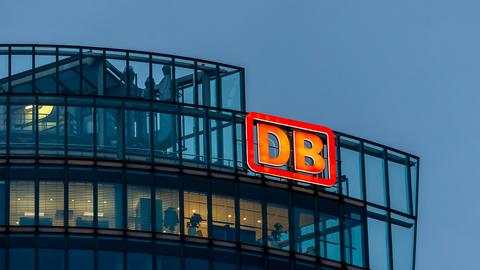 Das Bild zeigt die Vorstandsetage der Zentrale der Deutschen Bahn in der Dämmerung, außen am Gebäude prangt das rote DB-Logo.