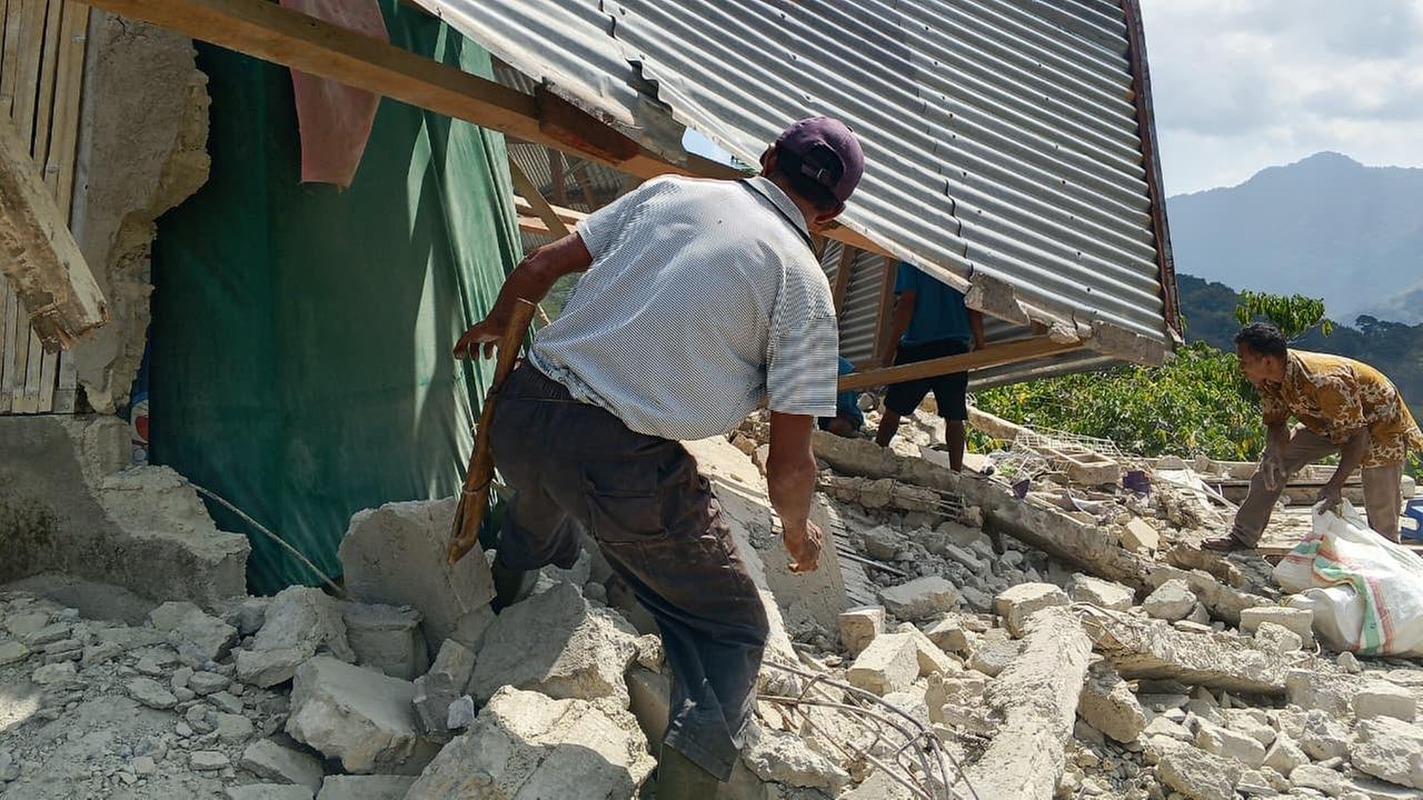 Menschen begutachten die Schäden an einem Haus nach einem Erdbeben. Menschen begutachten die Schäden an einem Haus nach einem Erdbeben.