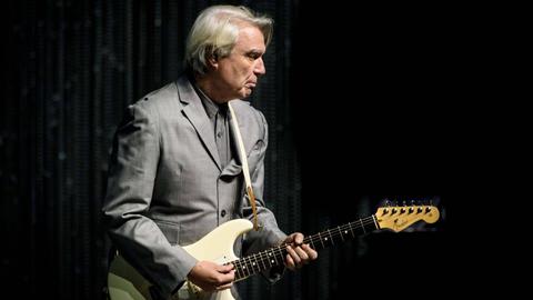 Porträt des schottischen Musikers David Byrne mit E-Gitarre auf einer Bühne, 2018.