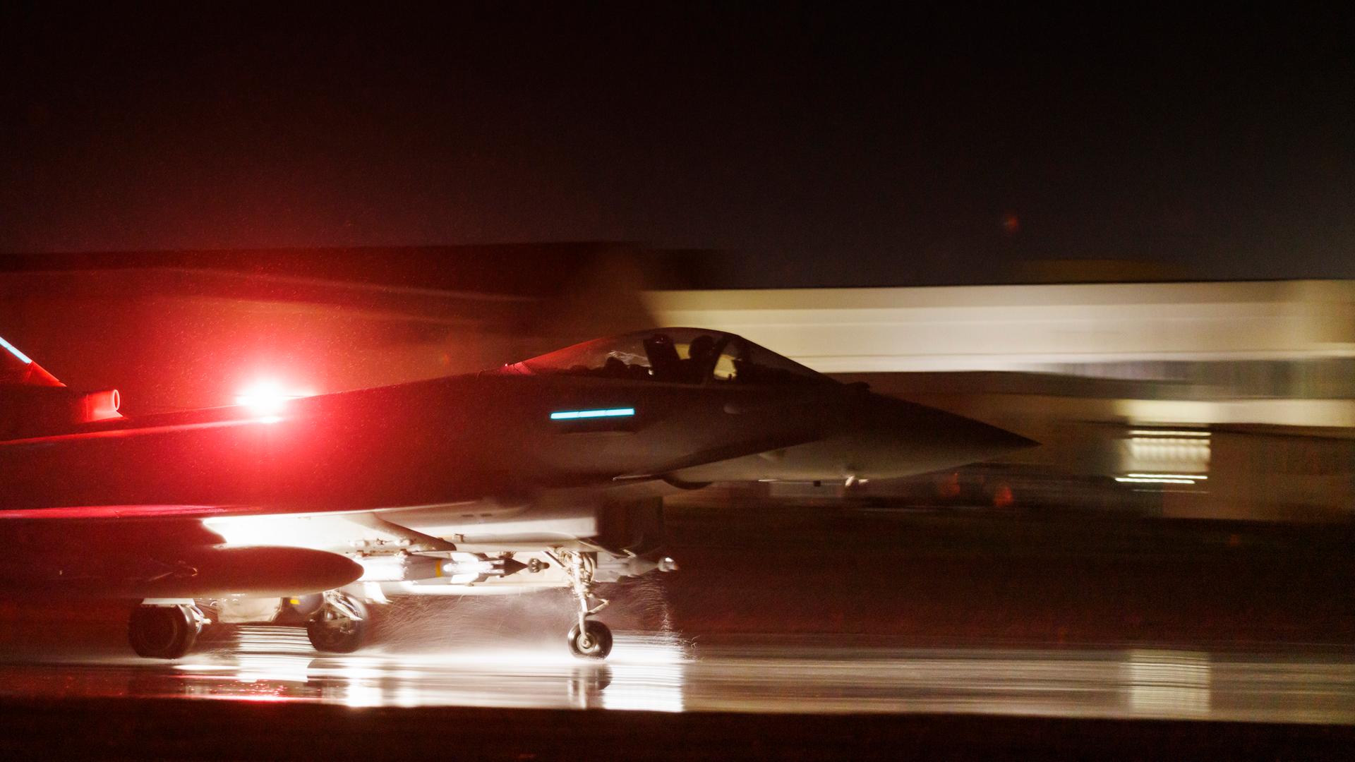 Ein Militärflugzeug startet im Dunkeln.