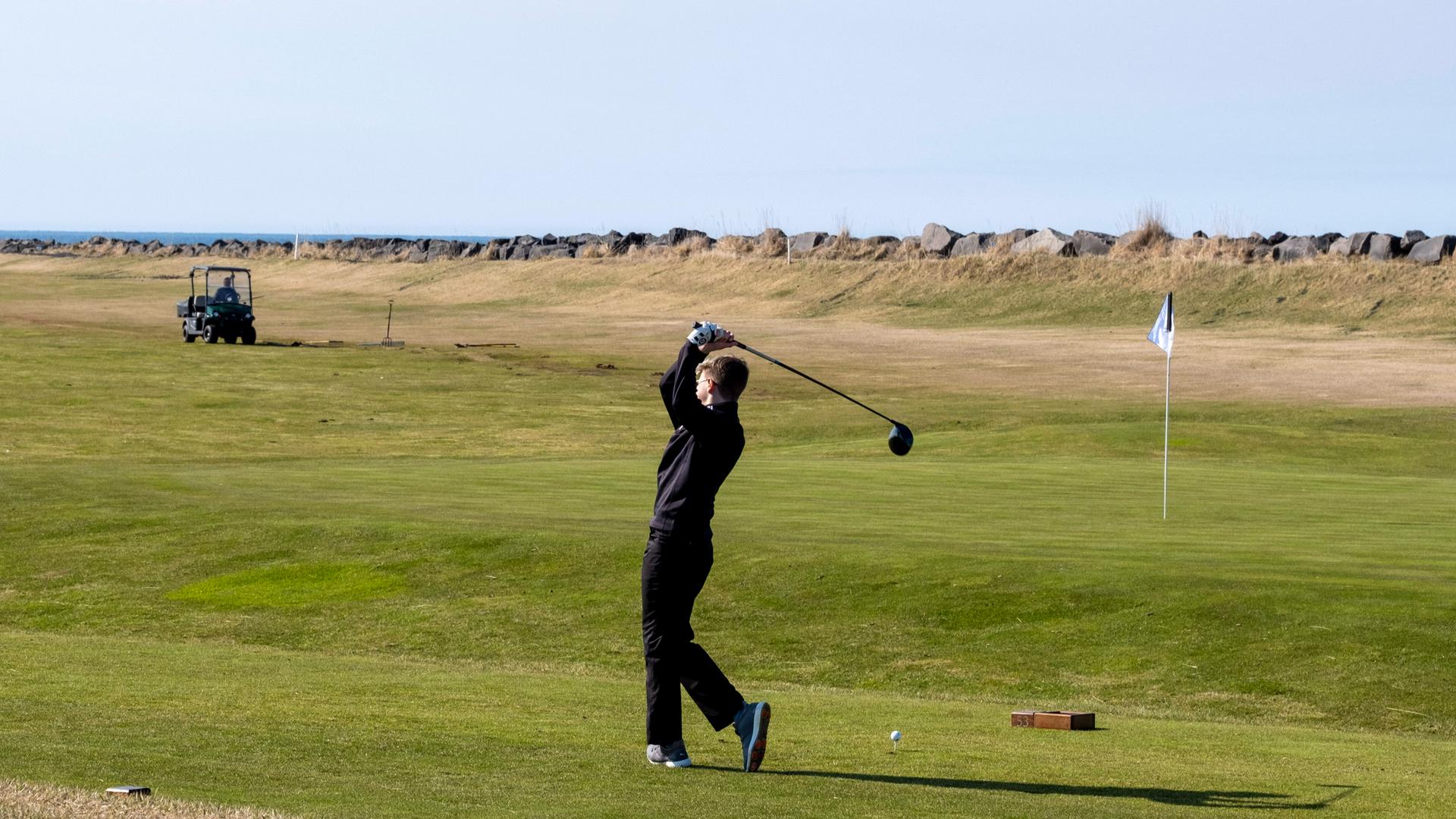 Ein Mann steht auf der Wiese und schwingt seinen Golfschläger durch die Luft. Ein Mann steht auf der Wiese und schwingt seinen Golfschläger durch die Luft.