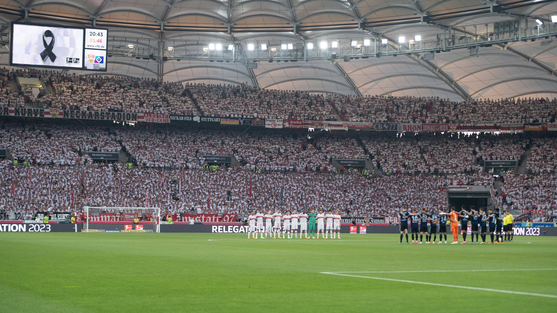 Das Foto zeigt die Mannschaften des VfB Stuttgart und Hamburger SV. Die Spieler haben sich auf dem Rasen in einer Riehe zu einer Schweigeminute aufgestellt.