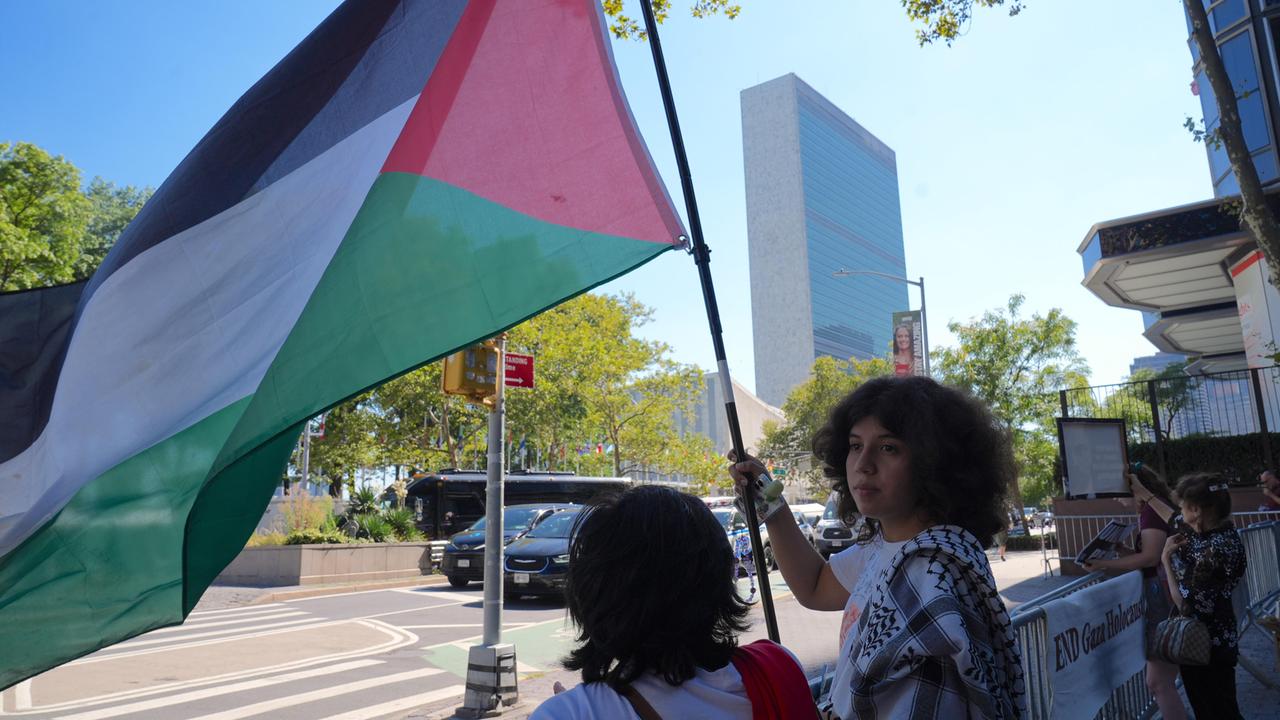Zwei junge Leute mit Palästinenserfahne vor den Vereinten Nationen in New York. Zwei junge Leute mit Palästinenserfahne vor den Vereinten Nationen in New York.