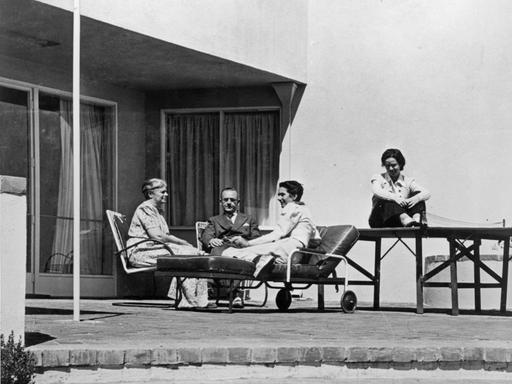 Historisches Schwarzweißfoto: Thomas Mann, seine Ehefrau Katia und die Töchter Erika und Monika sitzen auf der Terrasse seines Hauses in Pacific Palisades.