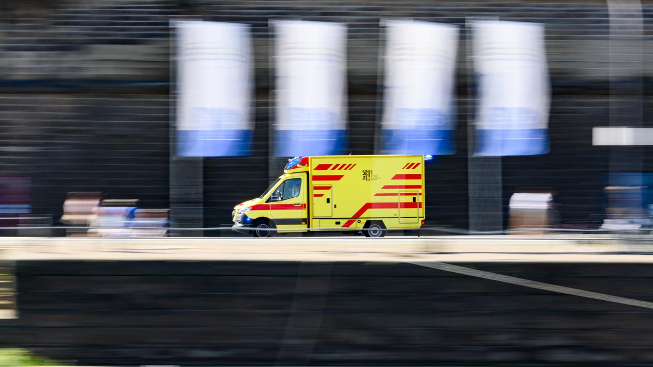 Ein Rettungswagen der Feuerwehr Dresden fährt am Terrassenufer entlang. 