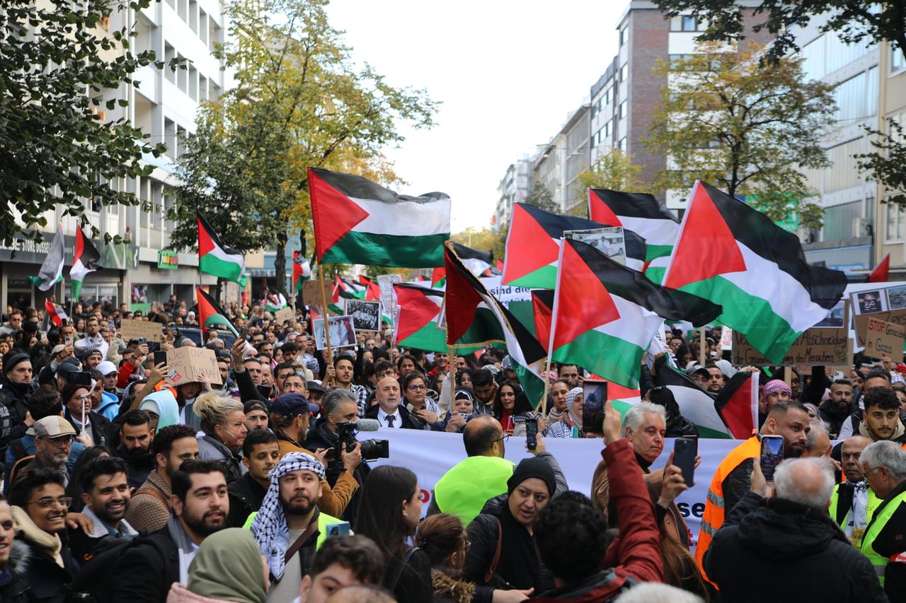 Eine Menschenmenge hält palästinensische Flaggen hoch 