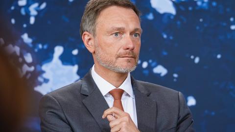 Bundesfinanzminister Christian Lindner FDP im Portrait bei der Pressekonferenz nach der Klausurtagung des Bundeskabinetts vor blauen Hintergrund.