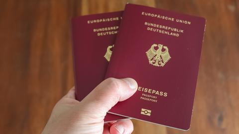 Eine Hand hält den deutschen Reisepass.