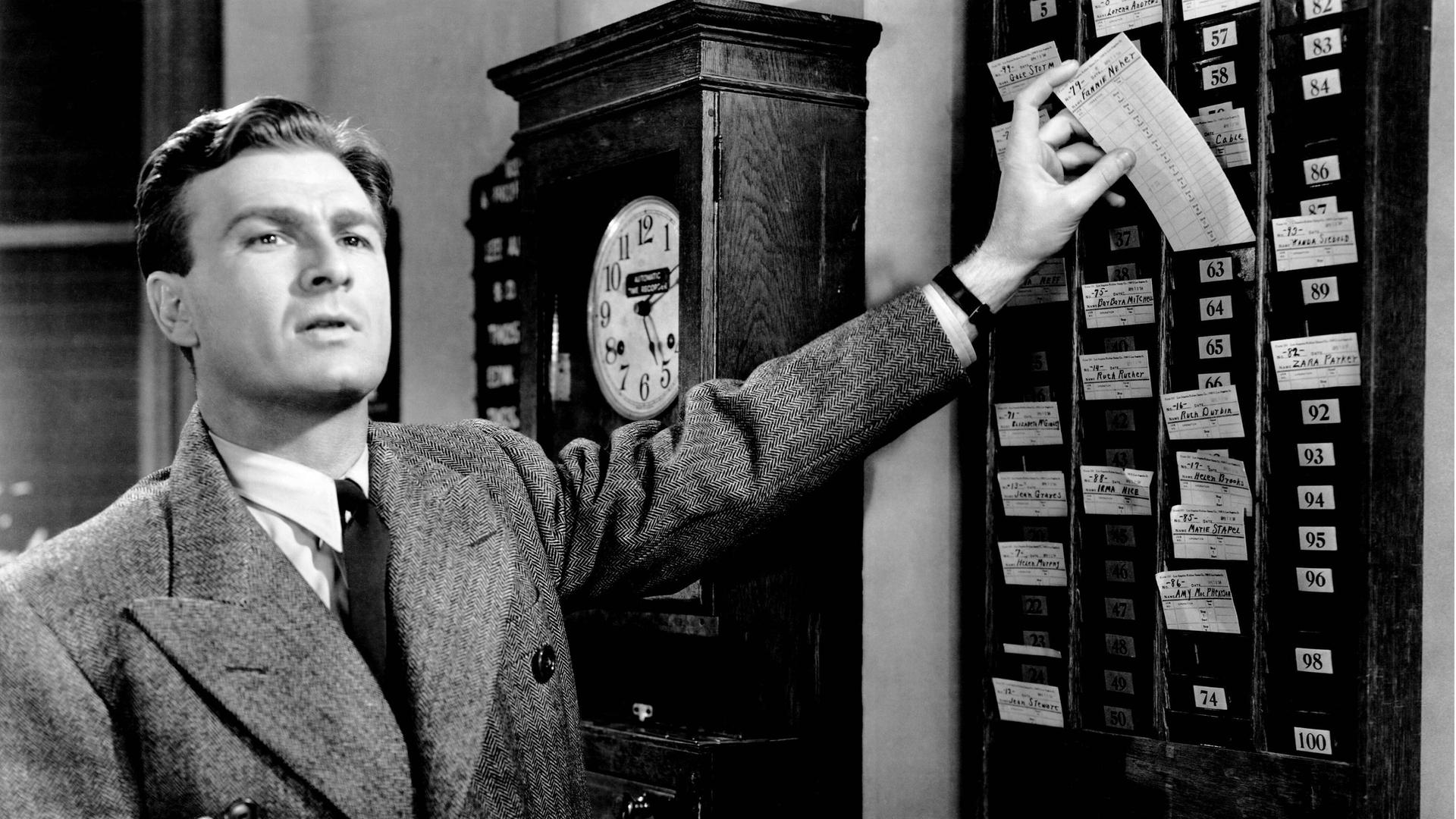 Ein Mann bedient eine Stechuhr (Szene aus dem Film "The Great Mr. Nobody" von 1941) 