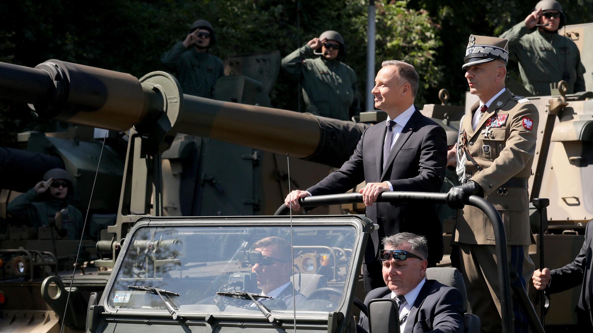 Andrzej Duda (2.v.r), Präsident von Polen, und General Rajmund Andrzejczak (r), Generalstabschef von Polen, nehmen an der Militärparade anlässlich des Tages der polnischen Streitkräfte teil.