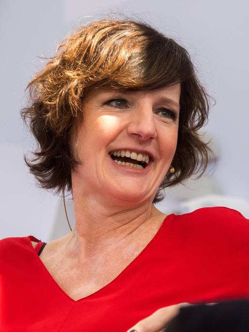 Die Autorin Doris Knecht wirft lachend den Kopf zur Seite.