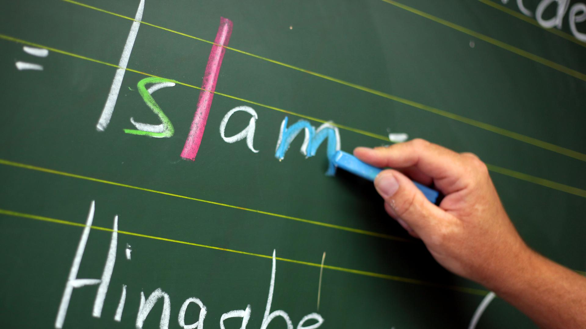 Ein Religionslehrer schreibt während des islamischen Religionsunterrichts an der Tafel.