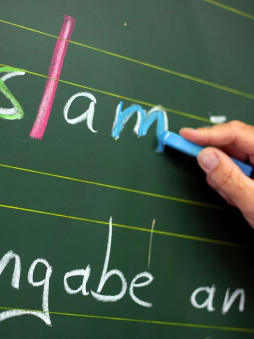 Ein Religionslehrer schreibt während des islamischen Religionsunterrichts an der Tafel.