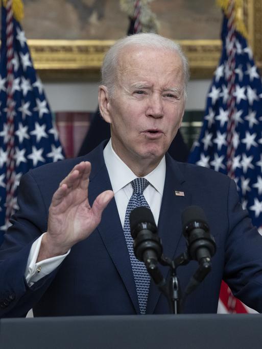 US-Präsident Joe Biden macht eine beschwichtige Geste an einem Rednerpult, hinter ihm die amerikanische Flagge.