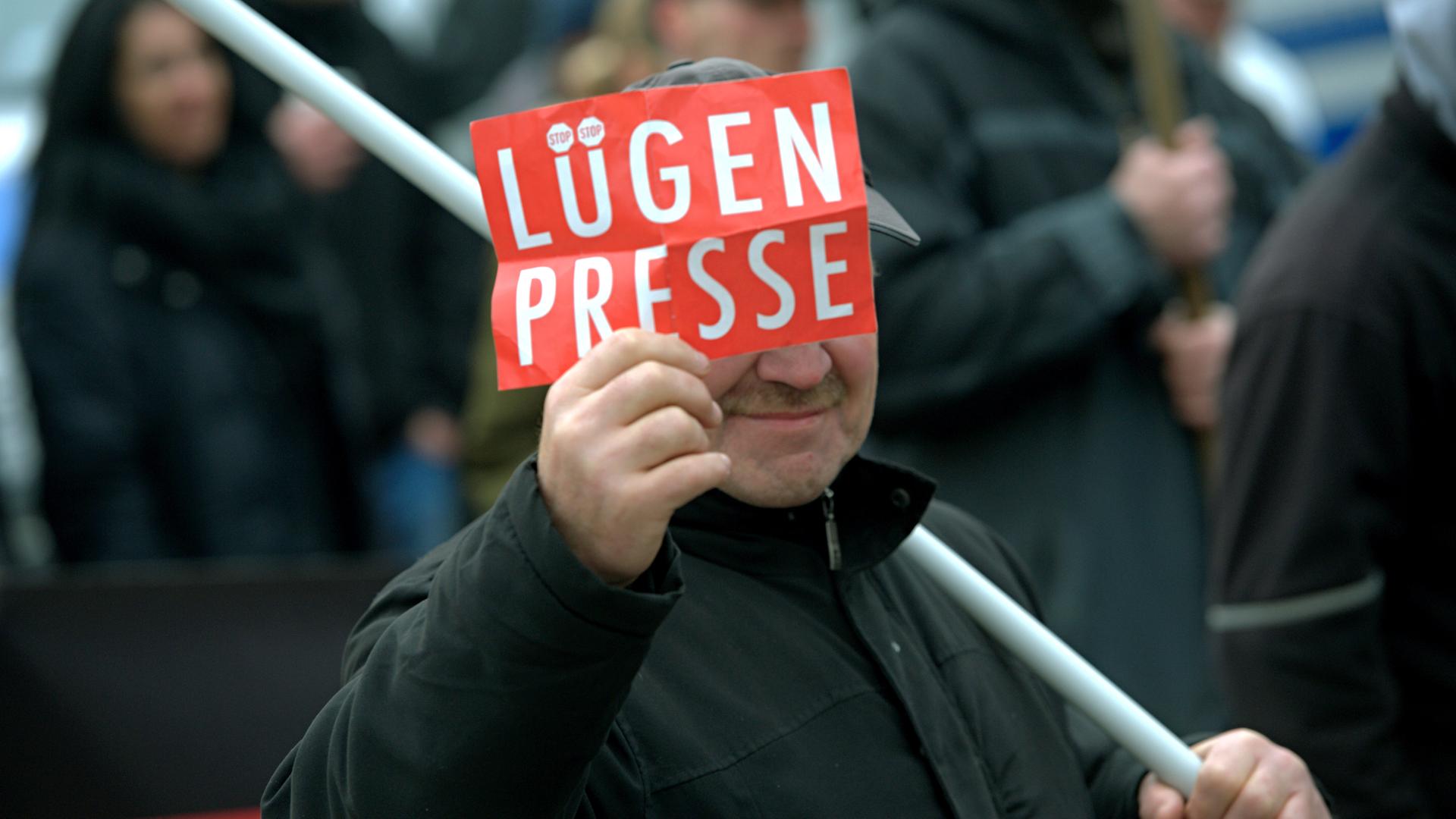 Ein Mann auf einer Demonstration 2016 ein Schild mit der Aufschrift "Lügenpresse"