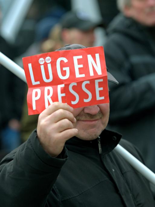 Ein Mann auf einer Demonstration 2016 ein Schild mit der Aufschrift "Lügenpresse"