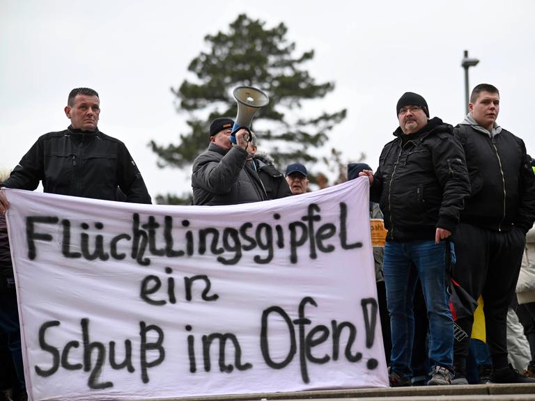 Vor der Malzfabrik Grevesmühlen protestieren Teilnehmer einer Demonstration während einer Sitzung des Kreistages Nordwestmecklenburg gegen die geplante Flüchtlingsunterkunft in Upahl.