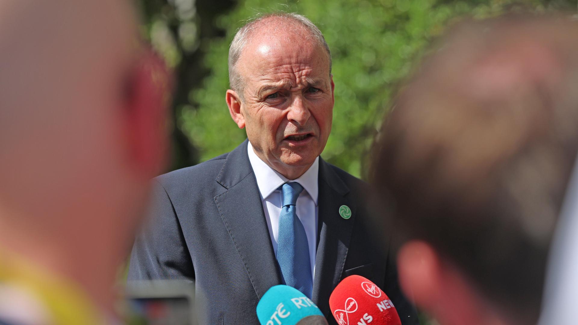 Der irische Regierungschef Martin steht vor Journalisten mit Mikrofonen und spricht. Der irische Regierungschef Martin steht vor Journalisten mit Mikrofonen und spricht.