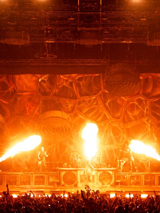 Bei einem Rammstein-Konzert sprühen drei Feuerfontänen über die Bühne.