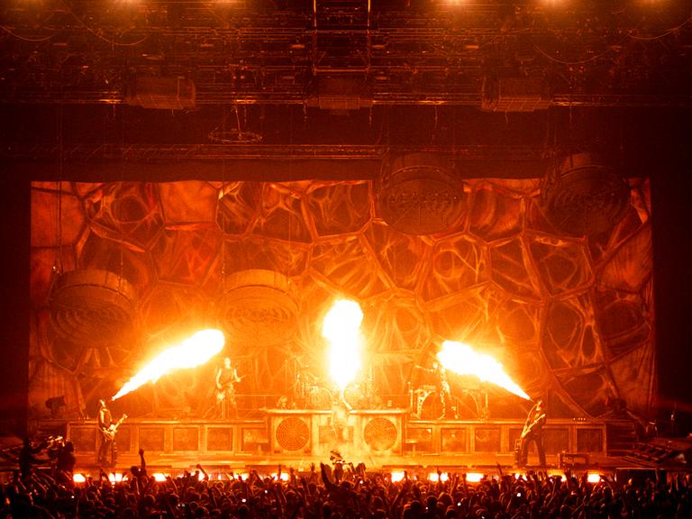 Bei einem Rammstein-Konzert sprühen drei Feuerfontänen über die Bühne.