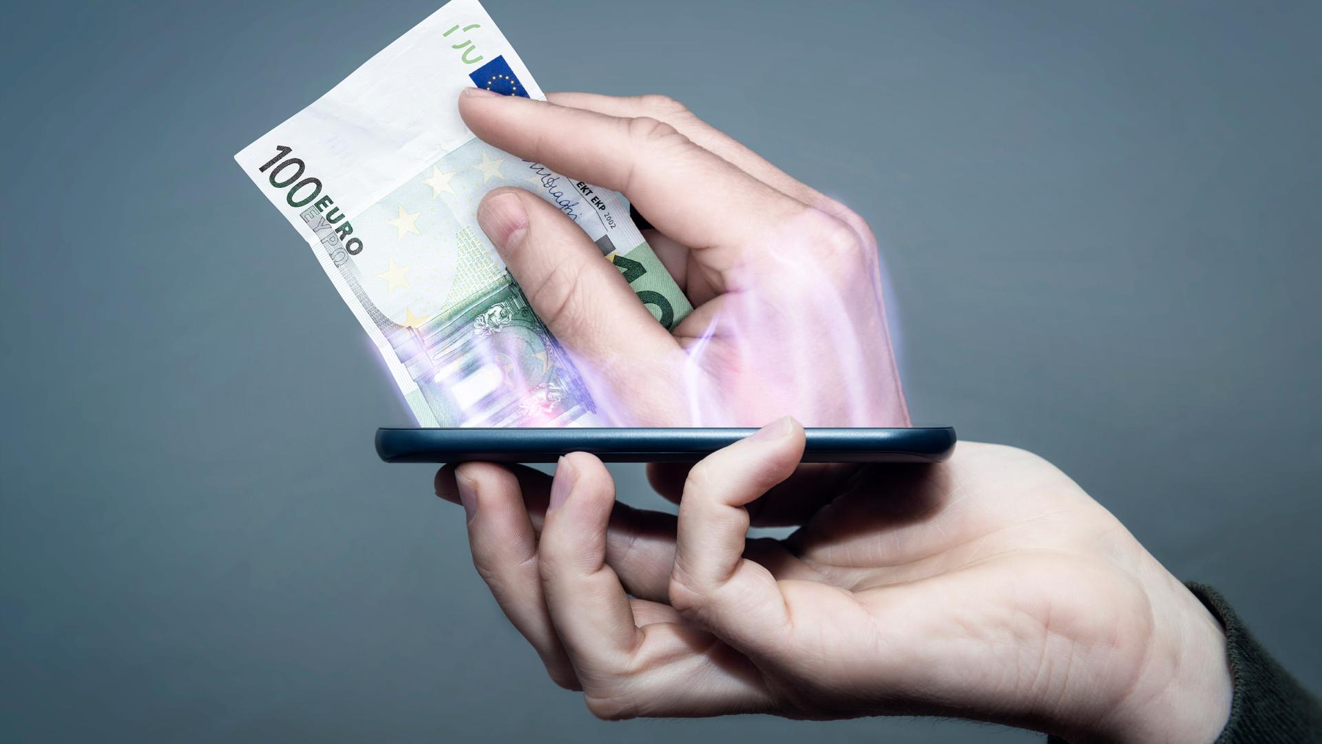 Eine Hand hält ein Smartphone, während eine andere Hand aus dem Display heraus ragt und bezahlt.