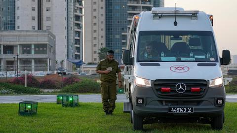 Israelische Sicherheitskräfte stehen neben einem Krankenwagen vor dem Hubschrauberlandeplatz eines Krankenhauses.