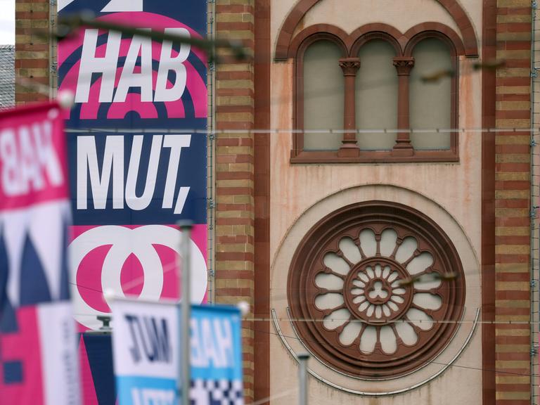 Der Slogan "HAB MUT, STEH AUF!" steht auf Bannern an den Türmen des Kiliansdoms in Würzburg.