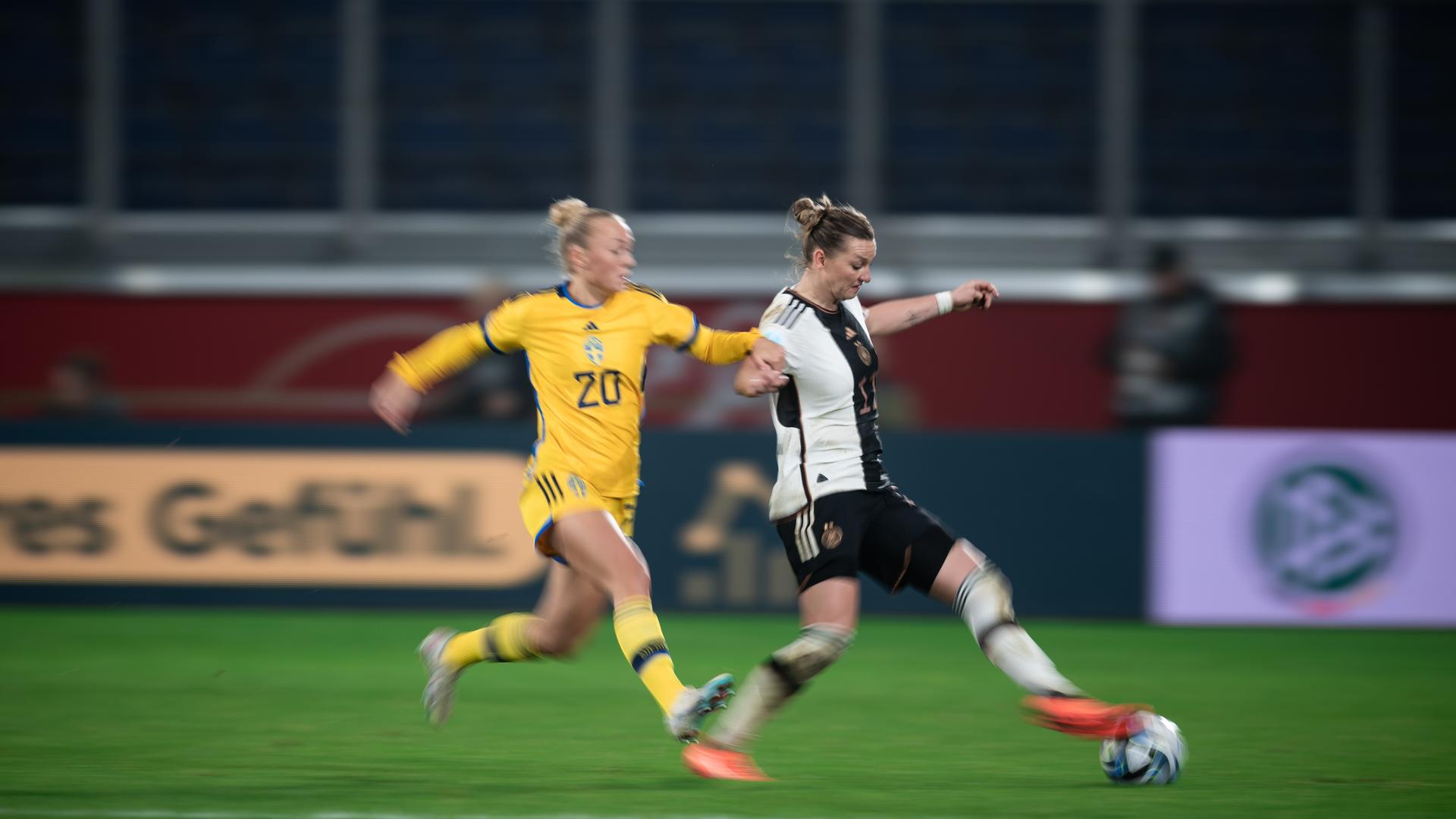 Die schwedische Spielerin Hanna Bennison links kämpft mit der deutschen Spielerin Alexandra Popp um den Ball.