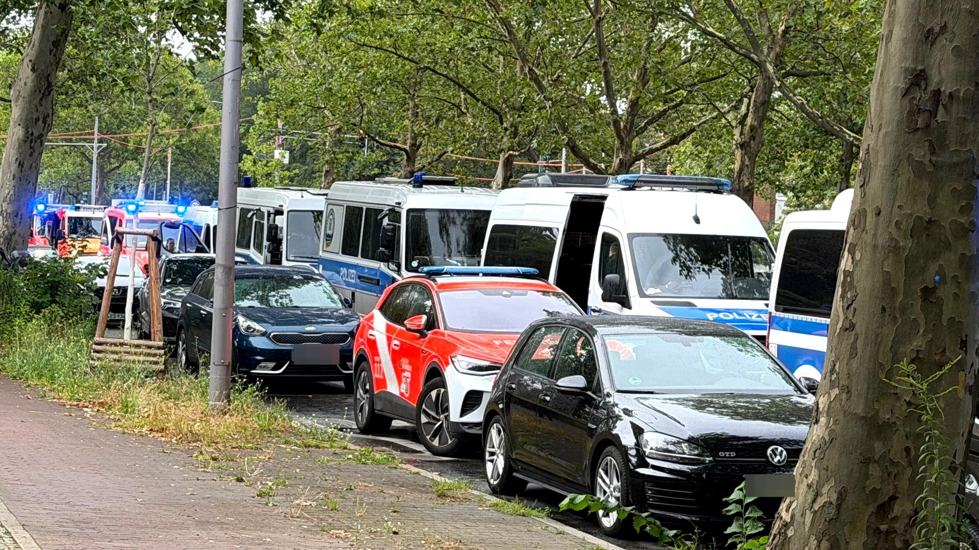 Einsatzfahrzeuge von Polizei und Feuerwehr stehen am Straßenrand nahe einer Kleingartenkolonie in Spandau. Einsatzfahrzeuge von Polizei und Feuerwehr stehen am Straßenrand nahe einer Kleingartenkolonie in Spandau.