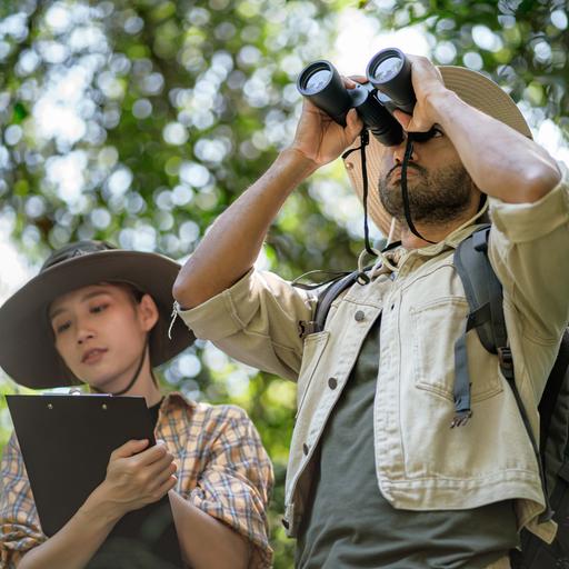 Zwei Ornithologen mit Fernglas und Kladde zur Aufzeichnung bei der Vogelbeobachtung