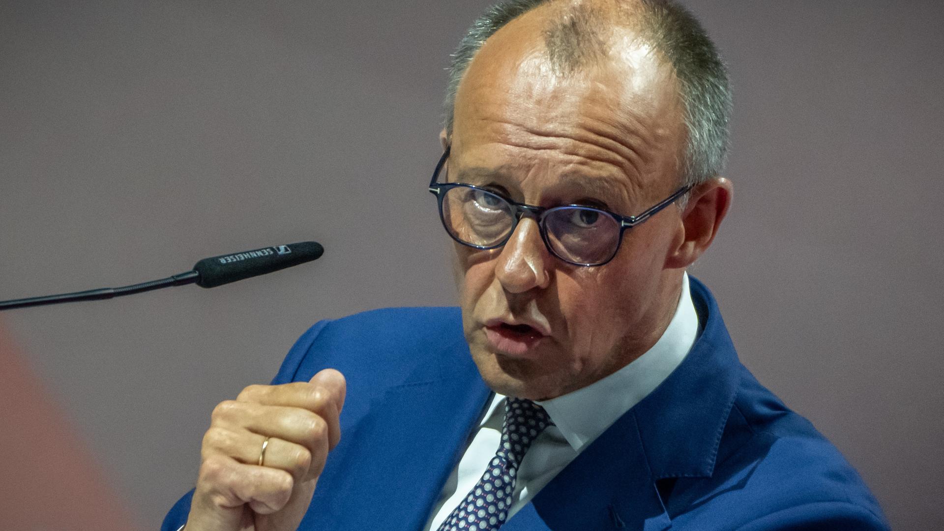 Bundeskanzler Friedrich Merz (CDU) spricht in ein Mikrofon. Er hat seine rechte Hand zur Faust geballt. Bundeskanzler Friedrich Merz (CDU) spricht in ein Mikrofon. Er hat seine rechte Hand zur Faust geballt.