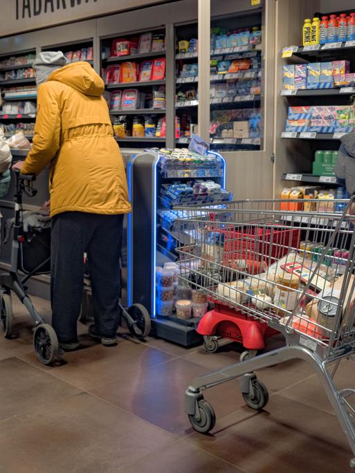 Kunden warten in einem Supermarkt an der Kasse.