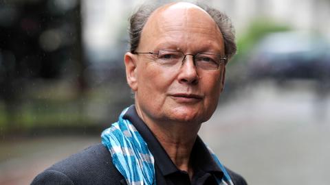 Ein älterer Mann mit Brille blickt in die Kamera.